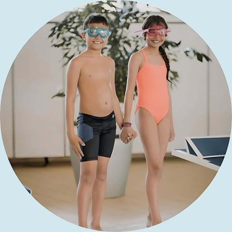 Dreng og piger i badebukser og badedragt holder hånd.